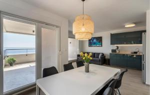 a dining room and living room with a white table and chairs at Cozy Apartment In Dingac With House Sea View in Gornji Dingač