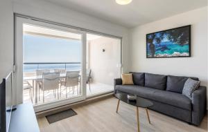 a living room with a couch and a view of the ocean at Cozy Apartment In Dingac With House Sea View in Gornji Dingač