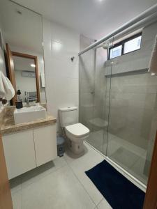 a bathroom with a shower and a toilet and a sink at Bangalô Camboinha triplex in Cabedelo +8 photos