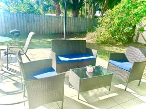 um pátio com cadeiras, uma mesa e um guarda-sol em Cozy Private Studio - 10 min Drive to Siesta Key Beach, Perfect for Couples em Sarasota
