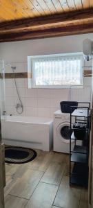 a kitchen with a tub and a sink and a washing machine at Willa Baśka in Chańcza +51 photos