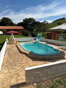 エストレーマにあるSítio do Beto Extrema MGの庭園内のスイミングプール(椅子付)