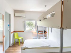 a bedroom with a bunk bed and a yellow chair at ibis Budget - Melbourne Airport in Melbourne