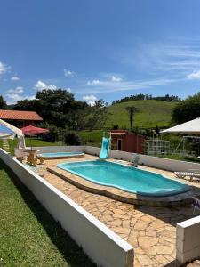 エストレーマにあるSítio do Beto Extrema MGの石造りの歩道を囲むスイミングプール