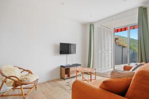 een woonkamer met een bank en een tv bij Le petit Sud in Carqueiranne +8 foto's