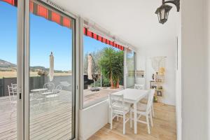 een eetkamer met een glazen schuifdeur naar een terras bij Le petit Sud in Carqueiranne