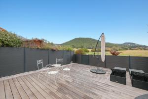 een houten terras met stoelen en een lamp erop bij Le petit Sud in Carqueiranne