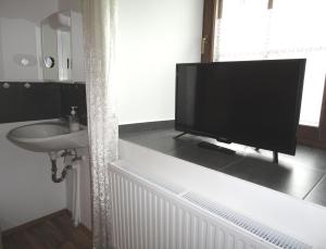 a bathroom with a television on a counter with a sink at Rentcenter79 in Vordernberg