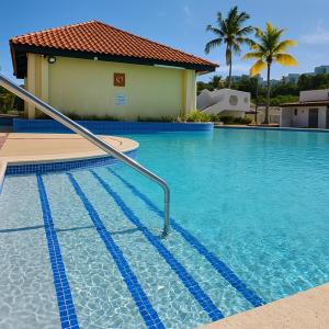 a swimming pool in front of a house at Sea Breeze Villa in Fajardo
