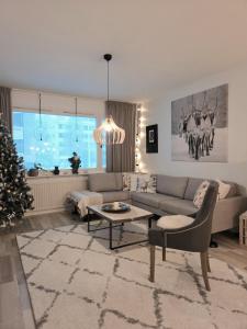 een woonkamer met een bank en een kerstboom bij Arctic Circle Home in Rovaniemi