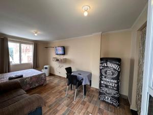 een kamer met een bed, een tafel en een bank bij Pousada por do sol in Niterói