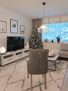 a living room with a christmas tree and a television at Arctic Circle Home in Rovaniemi