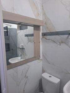 a bathroom with a toilet and a sink at Casa 2 Encanto dos Mares in Itapema