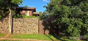 ein Holzzaun vor einem Haus in der Unterkunft Cabaña del Iguazu in Puerto Iguazú