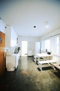 罗瓦涅米Santa's indoor Camping Hostel的厨房配有白色橱柜、桌子和长凳