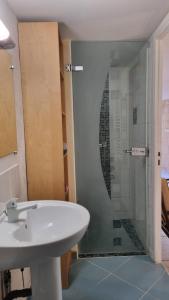 een badkamer met een wastafel en een glazen douche bij La suite d'Ananda in Villefranche-de-Rouergue