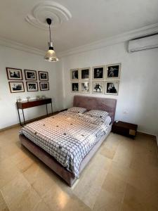 a bedroom with a bed and pictures on the wall at Adagio House - Best View - Marsa Gammarth Sup in La Marsa