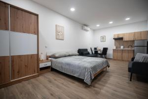 a bedroom with a bed and a table and a kitchen at Studio apartman MALA OAZA in Kistanje