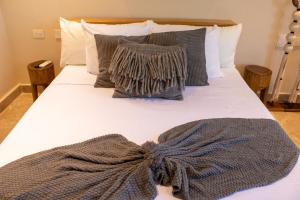 a bed with a blanket and a scarf on it at Peregrina Tulum 301C 1BR Condo in Tulum +37 photos