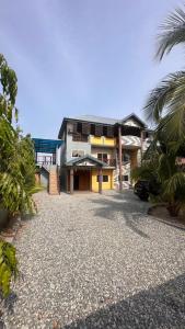 a building with a gravel driveway in front of it at Private Home with Access to Beach Front -Krokrobite in Kokrobite
