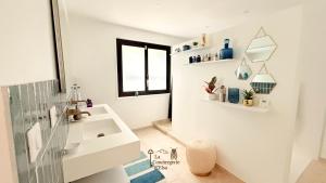 un bagno bianco con un lavandino e una finestra di La Chambre du Soleil a Arles