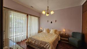 Un dormitorio con una cama y una lámpara de araña en casa de descanso, en Mar del Plata