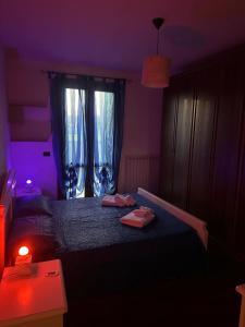 a purple bedroom with a bed with two towels on it at La Riviera in Mira