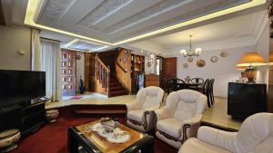 Una sala de estar con sillas, un televisor y una mesa. en casa de descanso, en Mar del Plata