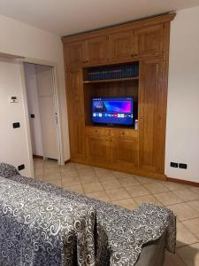 a bedroom with a tv in a wooden entertainment center at La Riviera in Mira