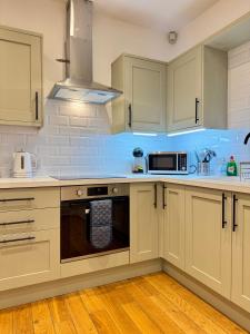 a kitchen with white cabinets and a microwave at Longsands Beach Apartment 1 Tynemouth Free Onsite Parking in Tynemouth +28 photos