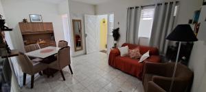Espaço do acalanto- Quarto em apartamento compartilhado في ناتال: غرفة معيشة مع أريكة حمراء وطاولة