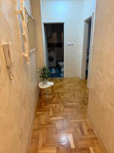 a hallway with a table and a room with a toilet at Apartman Odmor012 in Požarevac +41 photos