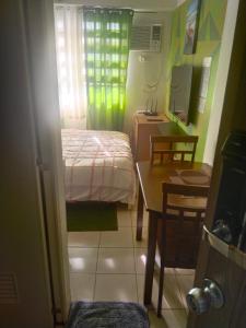 a small room with a bed and a table and a desk at Nicecondotel in Manila