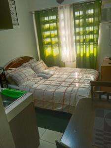 a bedroom with a bed in a room with windows at Nicecondotel in Manila