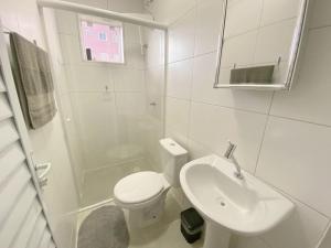 Un baño blanco con inodoro y lavabo. en Space DR7, en São José dos Pinhais 6 fotos más