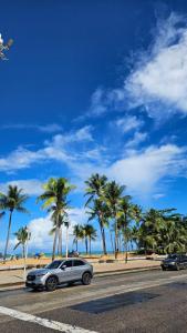 a car parked on the side of a road with palm trees at Paradise Hostel Recife Sul in Recife +9 photos