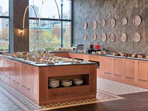 un restaurante con un mostrador con platos en ibis Styles Sarajevo, en Sarajevo