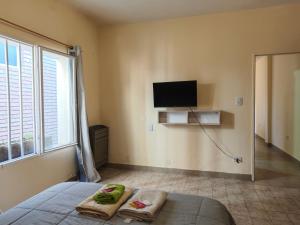 a bedroom with a bed and a tv on the wall at Keóken a la vuelta del casino in Caleta Olivia
