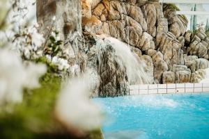 a waterfall in front of a rock wall at Hotel Jagdhof in Riezlern