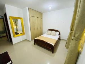 a small bedroom with a bed and a mirror at Hotel Piedra Mágica in Capurganá