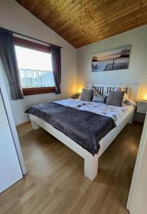 a bedroom with a large bed and a window at Ferienhaus Küstenzauber Simonsberg Nordsee Meer Husum in Simonsberg