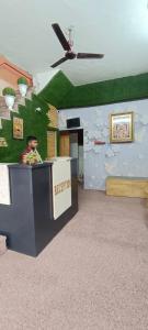 a man is sitting at a counter in a room at Hotel Devi Residency Vrindavan - Near Premanand ji Maharaj And Prem Mandir, Banke Bihari ji in Jāmb