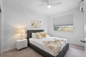 a white bedroom with a bed and a window at Marbella Lane - Elegant 3BR w Marvelous Views in Waianae +98 photos