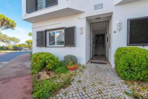 a white house with a gate and bushes at Casa do Gil in Loulé