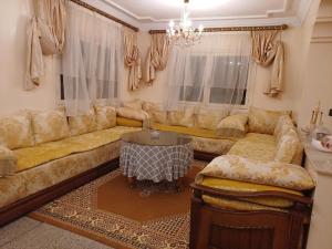 uma sala de estar com um sofá e uma mesa em Spacieux et familial à 2 minutes à pied du stade de football de RABAT em Rabat mais 17 fotografias