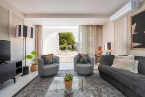 a living room with a couch and chairs and a television at Casa do Gil in Loulé