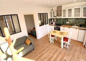 a kitchen and living room with a couch and a table at Appartement neuf & climatisé - 3 mins centre-ville in Prades