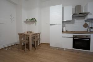 Una cocina con una mesa y sillas en una habitación. en Casa di Viola - Peonia, en Latina 2 fotos más