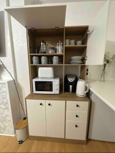 una piccola cucina con forno a microonde su una mensola di Barker House a Londra Altre 16 foto