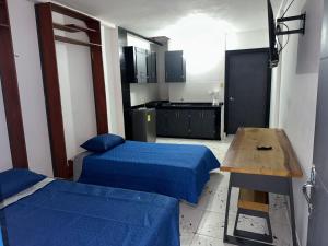 莱蒂西亚Casa Vacanza Apartamento 1的一间有两张床、一张桌子和一间厨房的房间